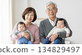 Twins being held by smiling grandparents. Family ties and happy moments. Copy space. 134829497
