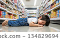 A boy in the "terrible twos" lying face down on the floor of a supermarket. The difficulties of raising a child. 134829694