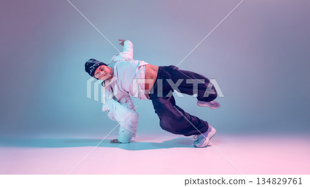 Breakdancer performing power move with dramatic lighting 134829761