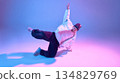 Breakdancer executing controlled floor pose with colored light. 134829769