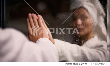 Woman touching foggy mirror after shower in bathroom 134829832