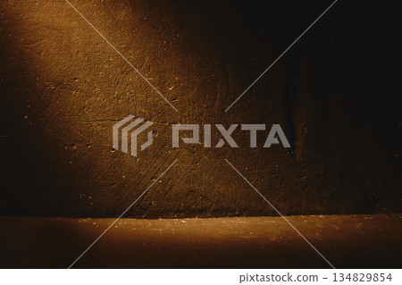 Dark brown textured wall background with dramatic light beam, rough surface and cinematic mood. Copy space 134829854