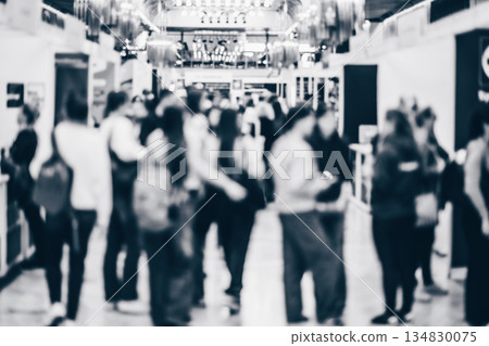 Abstract blurred people at exhibition hall of expo event trade show. Business convention show or job fair. Business concept background. Black and white image. Abstract blurred people at exhibition hall of expo event trade show. Business convention show or job fair. Business concept background. Black and white image. 134830075