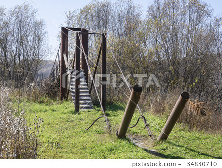 Iron pipes and cables of a suspension bridge in the village of Peteni in Siberia Iron pipes and cables of a suspension bridge in the village of Peteni in Siberia 134830710