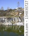 Huge cubic and geometric stone shapes are reflected in the water of the abandoned marble quarry 134830727
