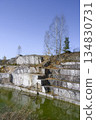 Huge geometric stone shapes and autumn birches reflected in the water of the abandoned marble quarry 134830731