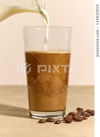 milk pouring in glass of coffee 134830859