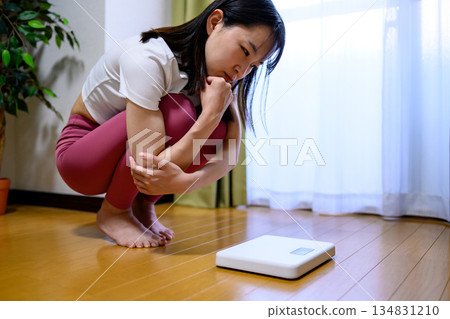 Woman in yoga wear shocked at scale, diet, leggings Woman in yoga wear shocked at scale, diet, leggings 134831210