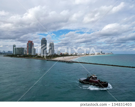 Tug boat passing canal. Miami South beach landscape aerial view. Skyline aerial on Miami south beach, Florida. Aerial Miami south beach. Landscape in South Beach, USA. Skyline panorama 134831403