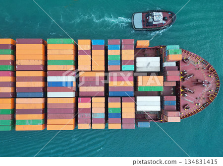 Cargo ship with container, top view. Freight container loaded on cargo vessel with tugboat. Aerial top view cargo ship with container. Cargo business. Container ship 134831415