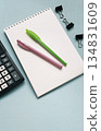 Notebook with calculator and pens on a blue background 134831609