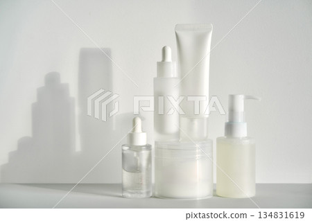 Skincare cosmetics arrangement with minimalist white background and strong shadows 134831619