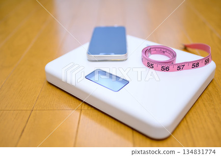 Place your smartphone and measuring tape on the scale on the floor. Place your smartphone and measuring tape on the scale on the floor. 134831774
