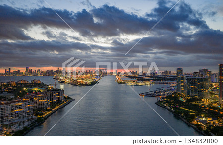Aerial night view of Miami coastline. Twilight skyline above the Miami oceanfront. Miami Beach waterfront glowing after sunset. 134832000