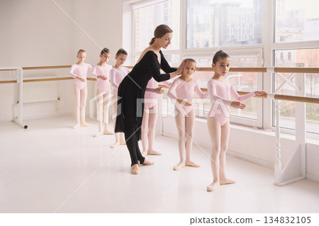 Ballet instructor adjusting head position of young dancer during class Ballet instructor adjusting head position of young dancer during class 134832105