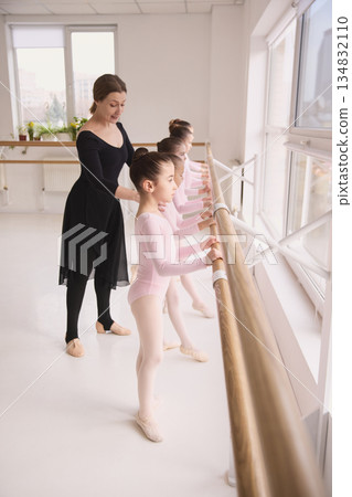 Ballet instructor guiding young dancer hand position during class Ballet instructor guiding young dancer hand position during class 134832110