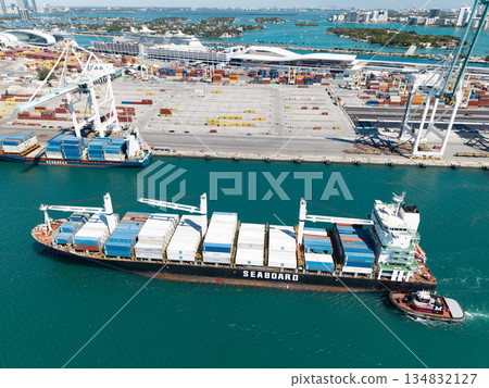 Miami, Florida, USA - March 20, 2025: Cargo ship vessel. Miami port logistic. Container Monrovia ship. Cargo Seaboard Explorer container ship, aerial view. Freight container cargo vessel and tugboat 134832127