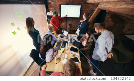 Team discussion around table in modern open office Team discussion around table in modern open office 134832142