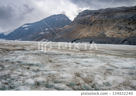 View into the Athabasca Glacier in Jasper National Park with cloudy sky with shoal visible. View into the Athabasca Glacier in Jasper National Park with cloudy sky with shoal visible. 134832240