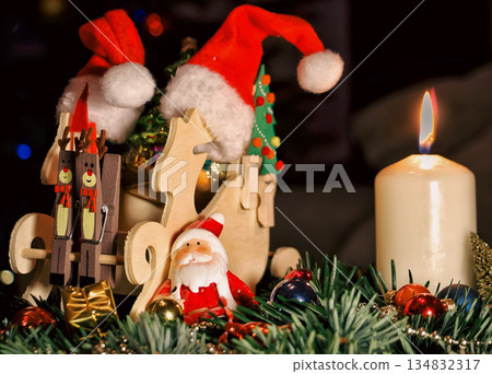 Wooden Sleigh with Santa Figurines and Ornaments in Festive Christmas Scene Wooden Sleigh with Santa Figurines and Ornaments in Festive Christmas Scene 134832317