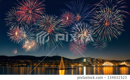 Fireworks Over Night City Reflected on Water with Floating Christmas Tree 134832323