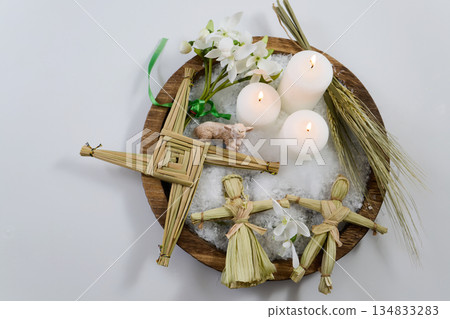 Imbolc altar with brigid's cross, candles, and corn dollies 134833283