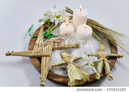 Imbolc altar with brigid's cross, dolls, candles, and lamb 134833285
