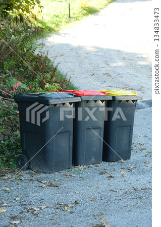 Garbage sorting in Europe. Garbage cans with colorful lids for different types of garbage Garbage sorting in Europe. Garbage cans with colorful lids for different types of garbage 134833473