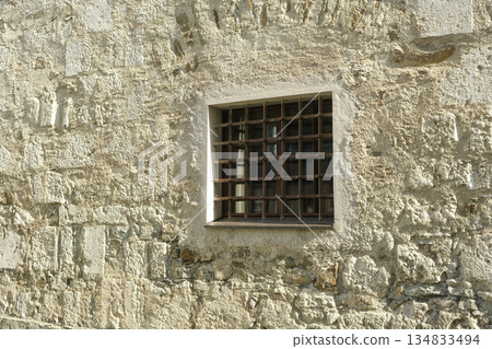Small Square Barred Window in a Rough Stone Wall 134833494