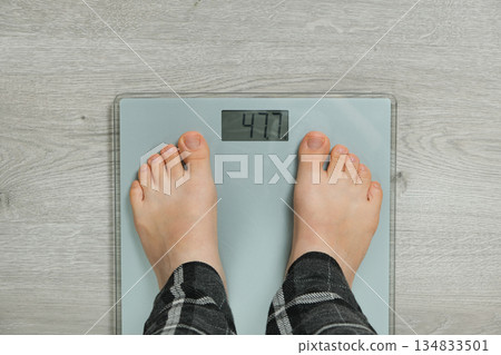 Top View of Bare Feet Standing on Modern Digital Bathroom Scales for Weighing. 134833501