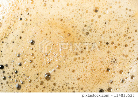 Macro texture of golden coffee foam with many small bubbles. Macro texture of golden coffee foam with many small bubbles. 134833525