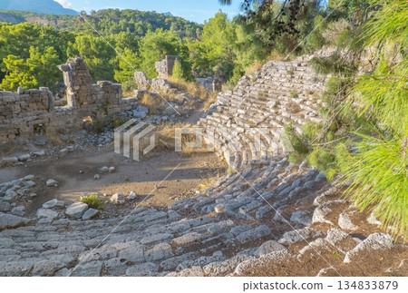 Ancient amphitheater ruins at the Ancient City of Phaselis in Tirki, surrounded by trees and rocky terrain, showcasing historical architecture and natural beauty. Ancient amphitheater ruins at the Ancient City of Phaselis in Tirki, surrounded by trees and rocky terrain, showcasing historical architecture and natural beauty. 134833879