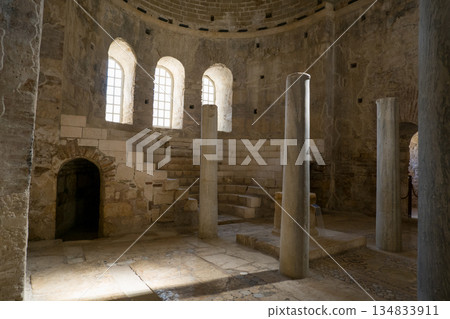 Sunlight illuminates the serene interior of St. Nicholas Church in Demre, Turkey, highlighting the ancient stone columns and arched windows. The timeless architecture and tranquil atmosphere evoke the 134833911