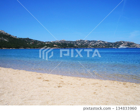 Beautiful beach view in Olbia, Sardinia, featuring crystal-clear turquoise water, white sandy shore, and the pristine Mediterranean coastline. Sunlit sea, gentle waves, and a relaxing coastal Beautiful beach view in Olbia, Sardinia, featuring crystal-clear turquoise water, white sandy shore, and the pristine Mediterranean coastline. Sunlit sea, gentle waves, and a relaxing coastal 134833960