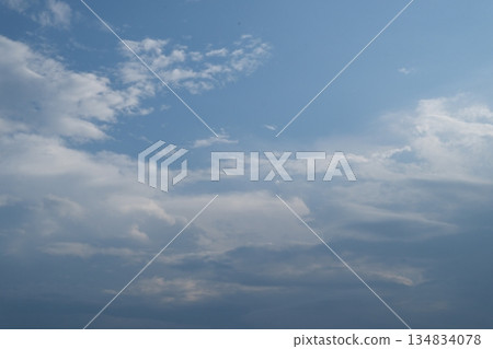 A mostly clear, pale blue sky with a few small white clouds. A mostly clear, pale blue sky with a few small white clouds. 134834078