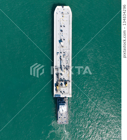 Tanker pushed by tugboat in sea. Cargo tanker ship transportation. Sea transportation. Ocean vessel. Sea transport. Large tanker transportation. Ship for cargo and tugboat, top view 134834296