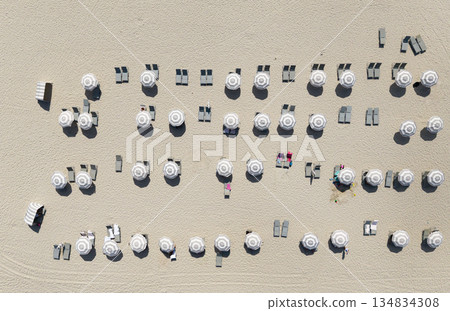 Vacation on summer. Tropical coastline. Summer vacation. Beach vacation at sea in summer. Sea relax under beach umbrella. Travel to sea. Aerial top view of sand beach with sunbed and umbrella 134834308