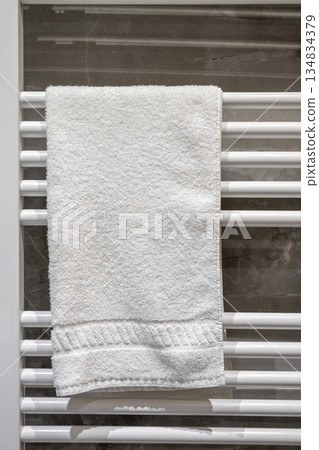 Towel drying on a rack in a bathroom after a shower in a modern home during daylight hours 134834379