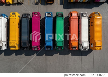 A row of brightly colored delivery trucks parked in a lot, viewed from above 134834633