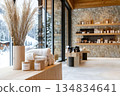 A spa shop interior with wooden shelves displaying products, fluffy towels, and candles near a window with a snowy mountain view 134834641