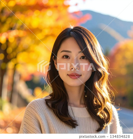 秋日的道路上，柔和的光線照亮了一個人，周圍環繞著色彩繽紛的秋葉。 134834828