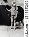 Vintage portrait of a little boy next to a historic tank. Retro photo from 1972 134835299