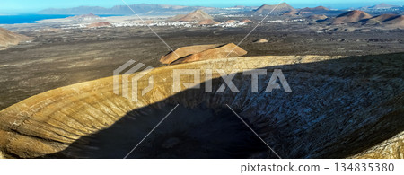 A volcano crater, beautiful volcanic mountains of Lanzarote, Canary islands at sunset. A volcano crater, beautiful volcanic mountains of Lanzarote, Canary islands at sunset. 134835380