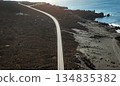 View from above on the road among black basalt rocks and lava formations. 134835382