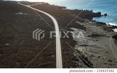 View from above on the road among black basalt rocks and lava formations. 134835382