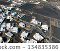 White buildings, town among volcanic black mountains and lava formations in Lanzarote, Canary Islands. 134835386