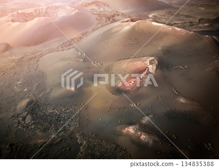 Astunning view of a volcano crater, desert, mountains and volcanoes on the Lanzarote island. Astunning view of a volcano crater, desert, mountains and volcanoes on the Lanzarote island. 134835388