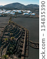 White buildings, town among volcanic black mountains and lava formations in Lanzarote, Canary Islands. 134835390