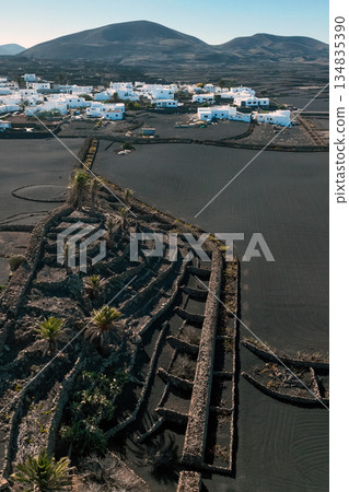 White buildings, town among volcanic black mountains and lava formations in Lanzarote, Canary Islands. White buildings, town among volcanic black mountains and lava formations in Lanzarote, Canary Islands. 134835390