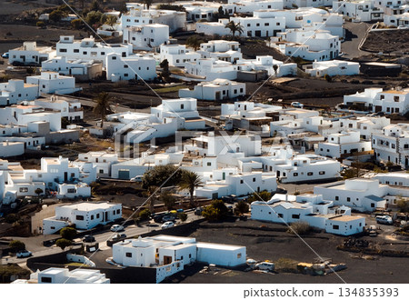 White buildings, town among volcanic black mountains and lava formations in Lanzarote, Canary Islands. White buildings, town among volcanic black mountains and lava formations in Lanzarote, Canary Islands. 134835393
